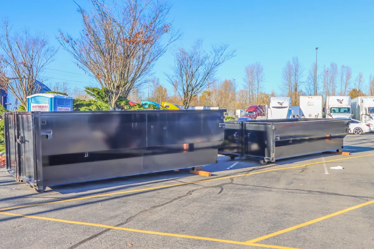 Professional dumpster rental service with roll-off container on residential driveway in Port Neches